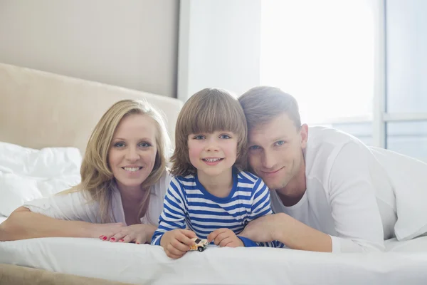 Padres felices acostados con su hijo — Foto de Stock