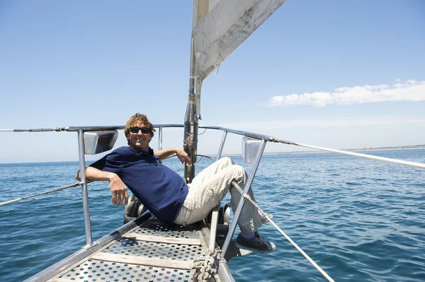 Człowiek siedzi na dziobie jachtu — Zdjęcie stockowe