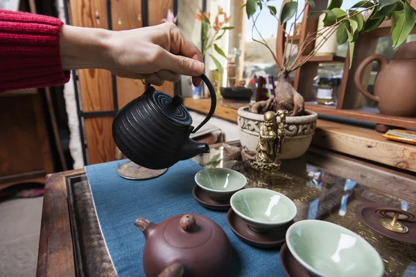 Mão derramando chá em xícaras de chá — Fotografia de Stock