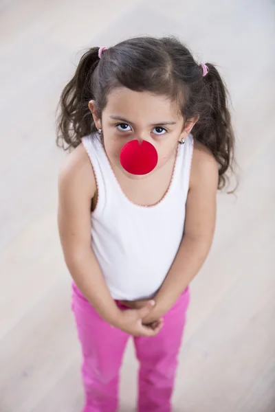 Menina usando nariz de palhaço — Fotografia de Stock