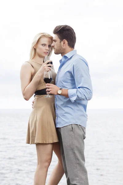 Couple having red wine against sea — Stock Photo, Image