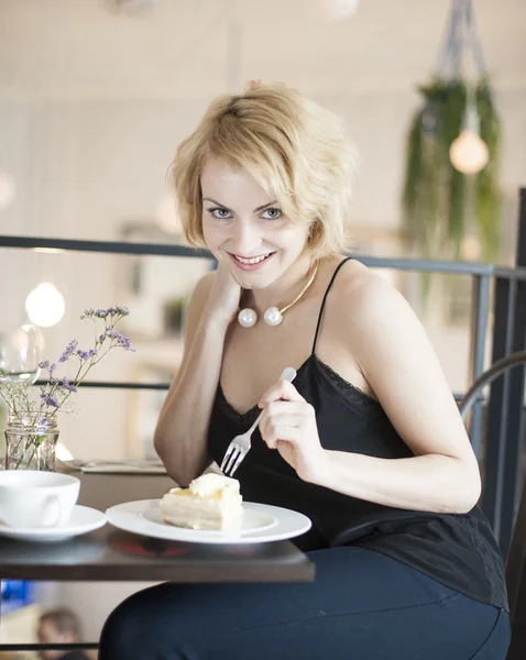 Glückliche junge Frau isst Kuchen — Stockfoto