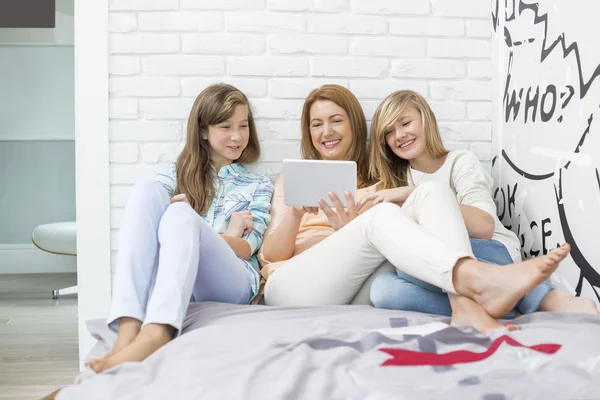 Mãe com filhas usando tablet digital — Fotografia de Stock