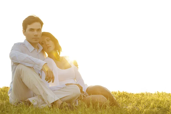 Мужчина сидит с девушкой на траве — стоковое фото