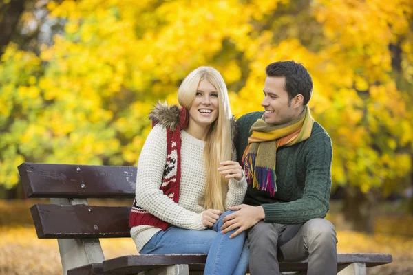 Couple sitting on park bench — Stock Photo, Image