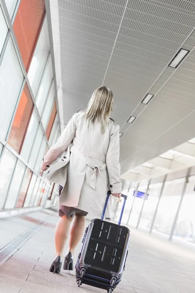 Businesswoman with luggage walking