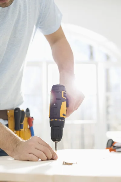 Man drilling nail — Stock Photo, Image