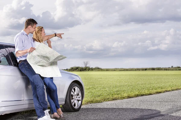 Couple with map discussing direction — Stock Photo, Image