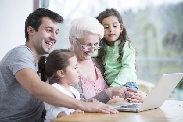 Tre generation familj använder laptop — Stockfoto