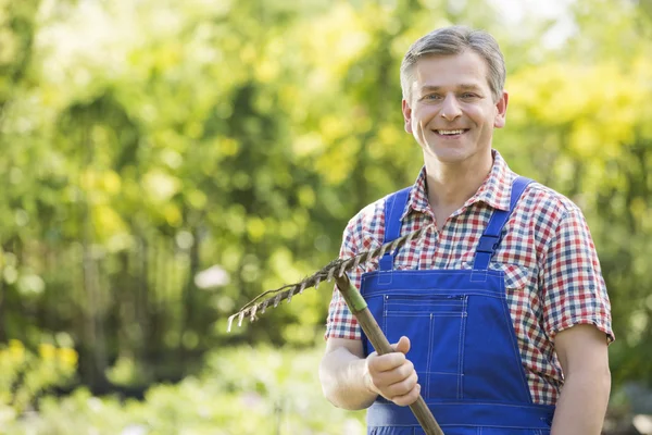 Gardener holding rake — Stock Photo, Image