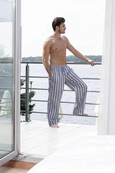 Man on hotel balcony looking away — Stock Photo, Image