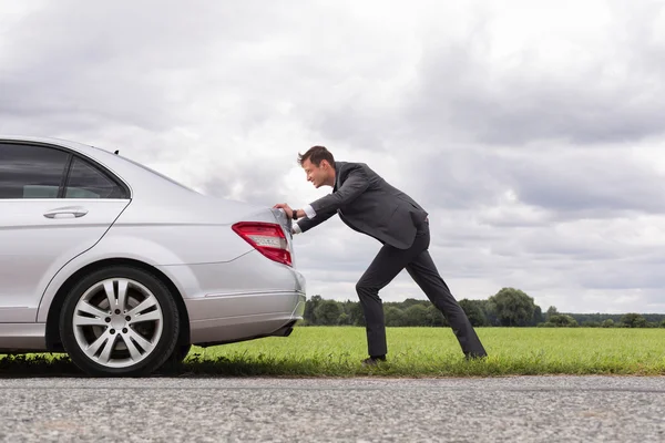 Uomo d'affari spingendo auto guasto — Foto Stock