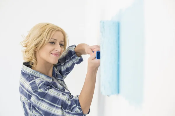 Vrouw schildert muur — Stockfoto