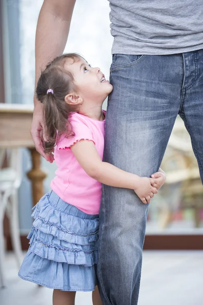 Девушка обнимает отца за ногу — стоковое фото
