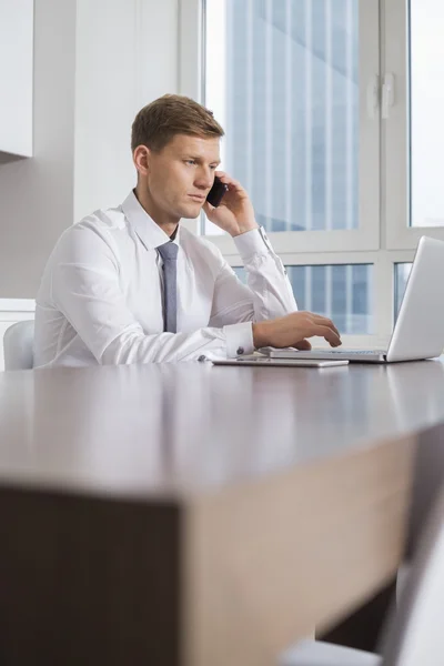 Affärsman på samtal när du använder laptop — Stockfoto