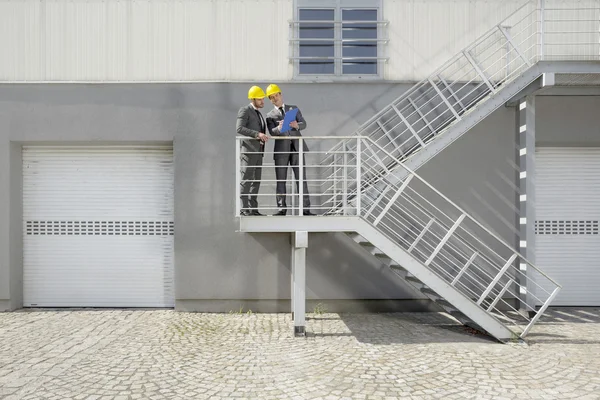 Ingenieure mit Klemmbrett diskutieren — Stockfoto