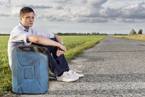 Man  sitting by country road — Stock Photo, Image
