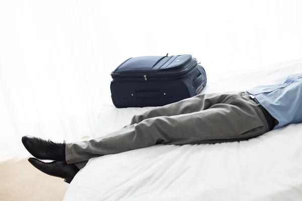 Hombre acostado en la cama en la habitación de hotel — Foto de Stock