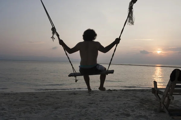 Hombre balanceándose en la playa — Foto de Stock