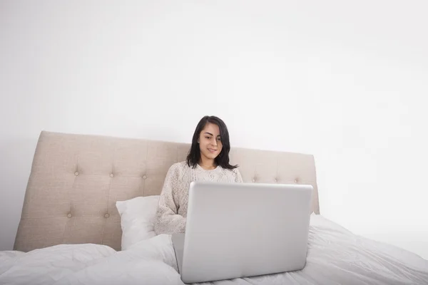 Mujer usando portátil en la cama — Foto de Stock