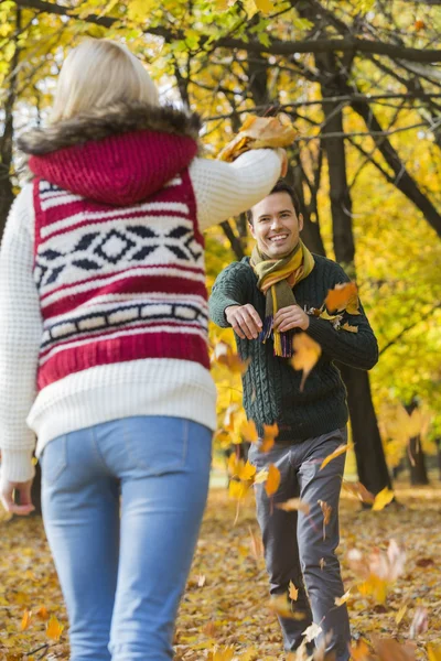 Couple playing with autumn leaves — Stock Photo, Image