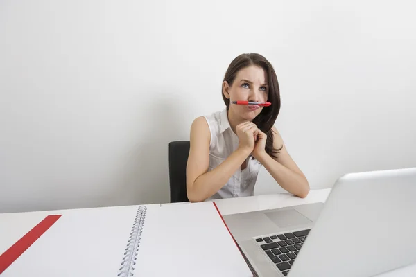 Empresária segurando caneta sob o nariz — Fotografia de Stock