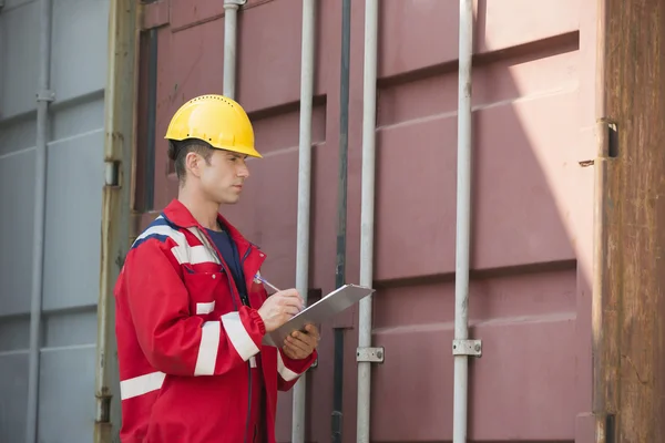 Trabajador inspeccionando contenedor de carga — Foto de Stock