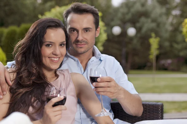 Casal tendo vinho tinto no parque — Fotografia de Stock