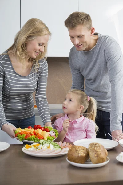 Eltern mit Tochter beim Essen Stockbild