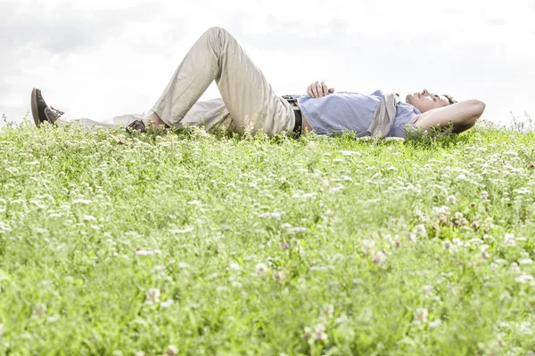 Man ligt op gras Rechtenvrije Stockafbeeldingen