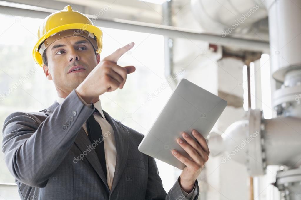 engineer with digital tablet pointing away