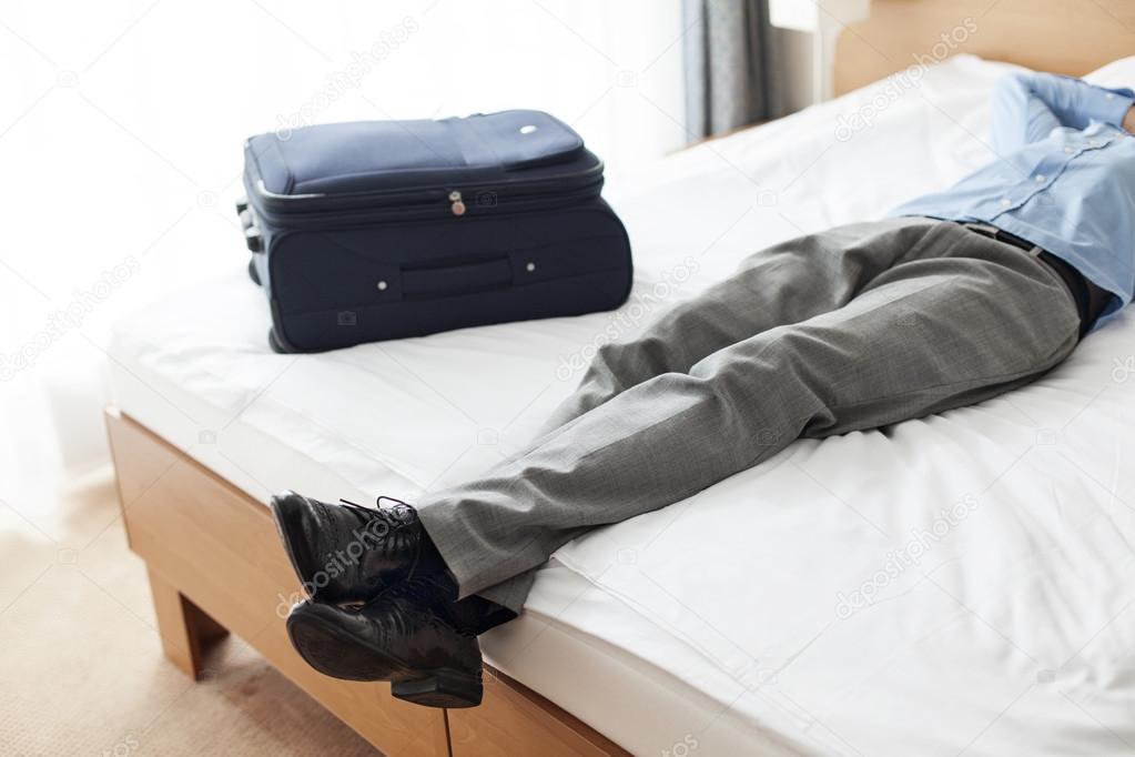 Man lying on bed in hotel room