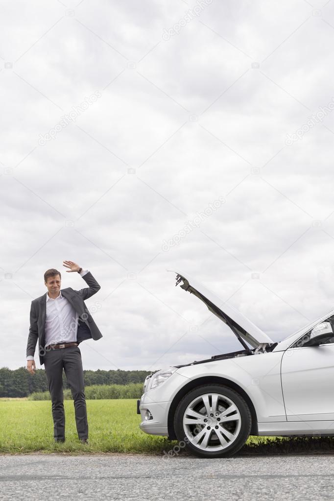 Young businessman waving for help