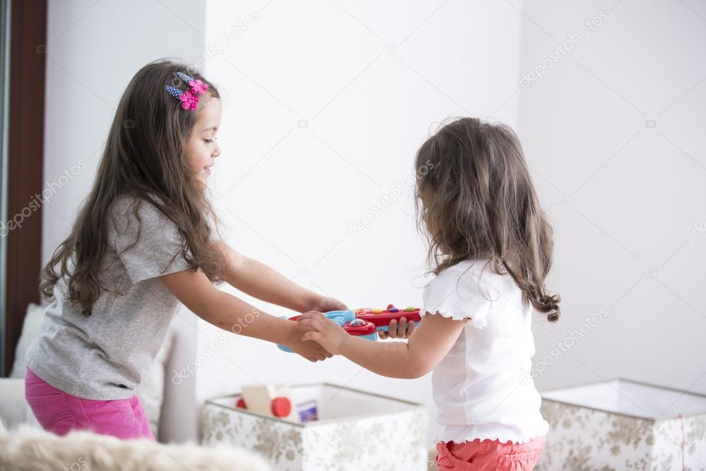 Sisters fighting for toy guitar