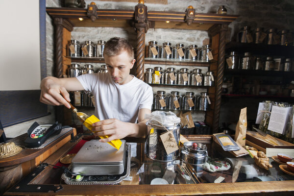 Владелец собирает ингредиент в бумажный пакет
