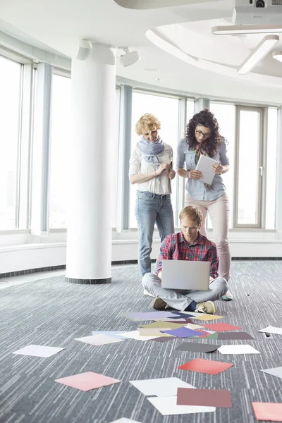 Businesswomen looking at  colleague using laptop — Stock Photo, Image