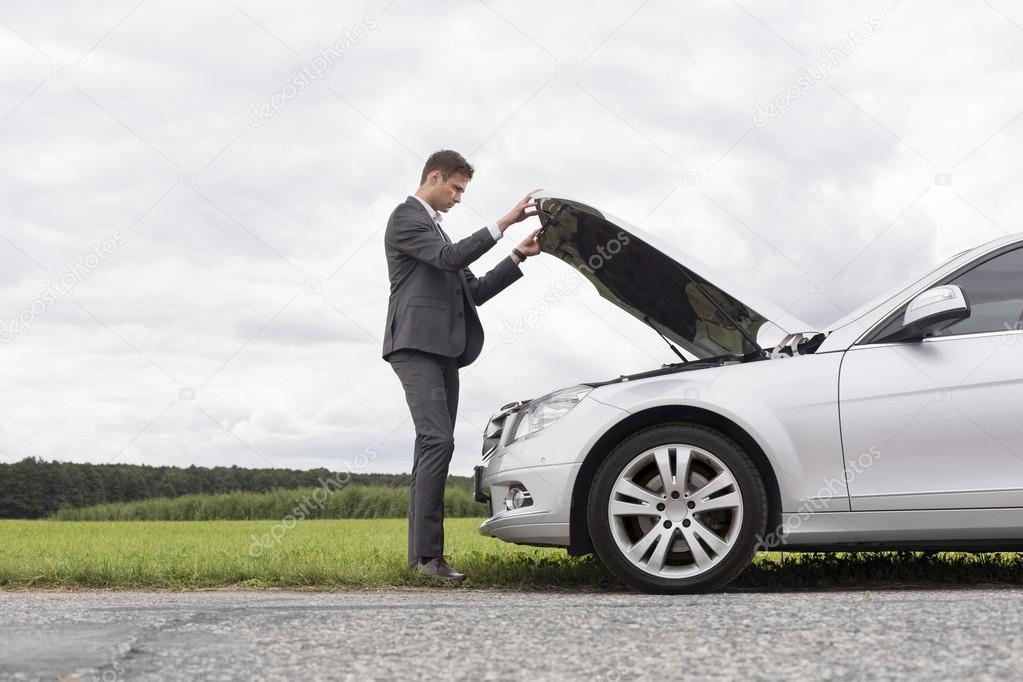 businessman opening car hood