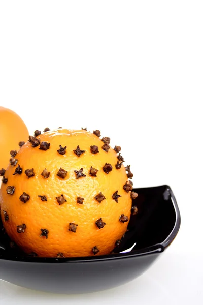 Oranges with cloves in bowl — Stock Photo, Image