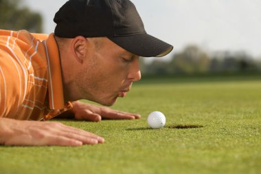 Adam golf topu üzerinde üfleme