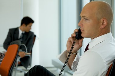 İş adamı telefonda konuşuyor.