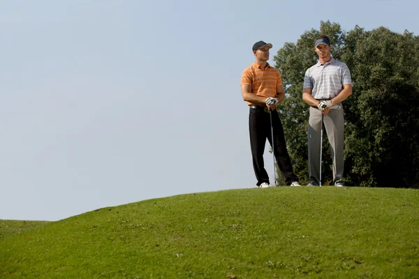 Män som stod med golf klubbor — Stockfoto