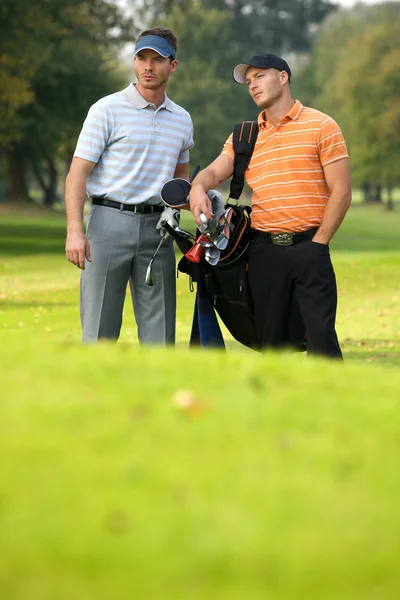 Hombres jóvenes de pie en el campo de golf — Foto de Stock