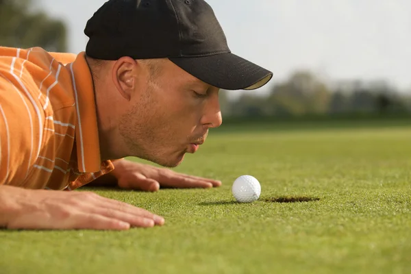 Homem soprando na bola de golfe — Fotografia de Stock