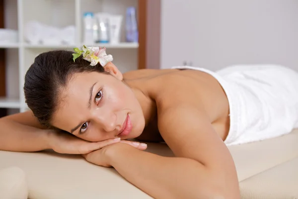 Mulher relaxante na mesa de massagem — Fotografia de Stock