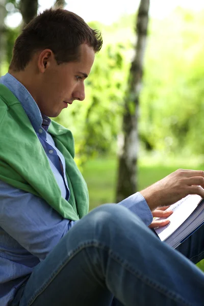 Man reading book in park — Stock Photo, Image