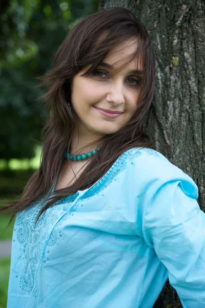 Woman standing by tree — Stock Photo, Image