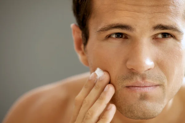 Hombre aplicando crema de afeitar — Foto de Stock