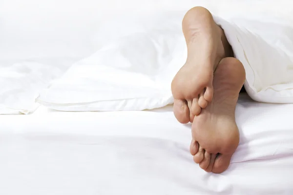 Die Füße der Person im Bett — Stockfoto