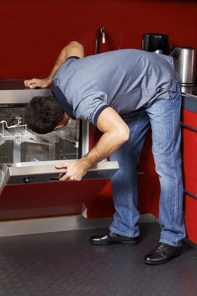 Pria yang melihat mesin cuci piring — Stok Foto