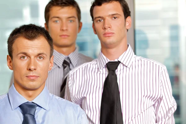 Drie zakenmensen poseren in office — Stockfoto